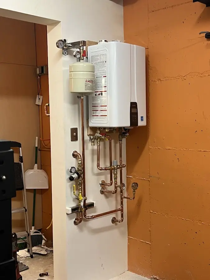 Plumbing technician inspecting water heater connections in Loomis
